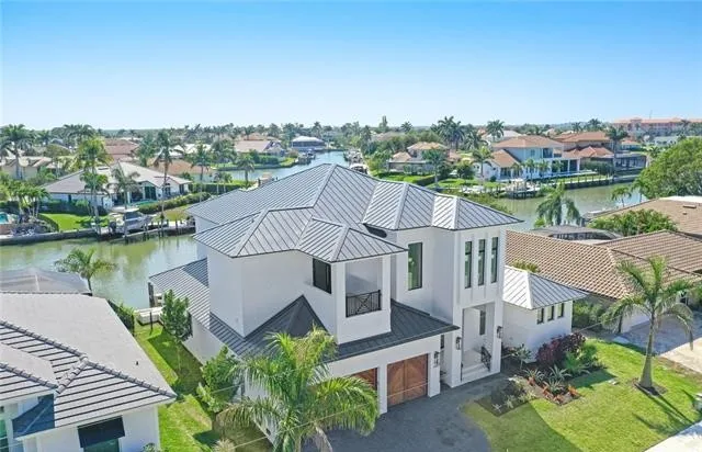 Modern Custom Home in Marco Island, a waterfront residence with a metal roof seen from the air