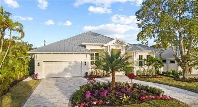 Modern Home in Naples, a single story house with a metal roof and a paver driveway
