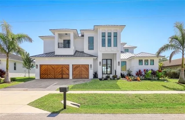 A completed two story custom home with wood garage doors and a metal roof